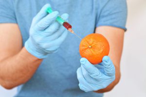 Student injecting an orange as a simulation of injection procedure